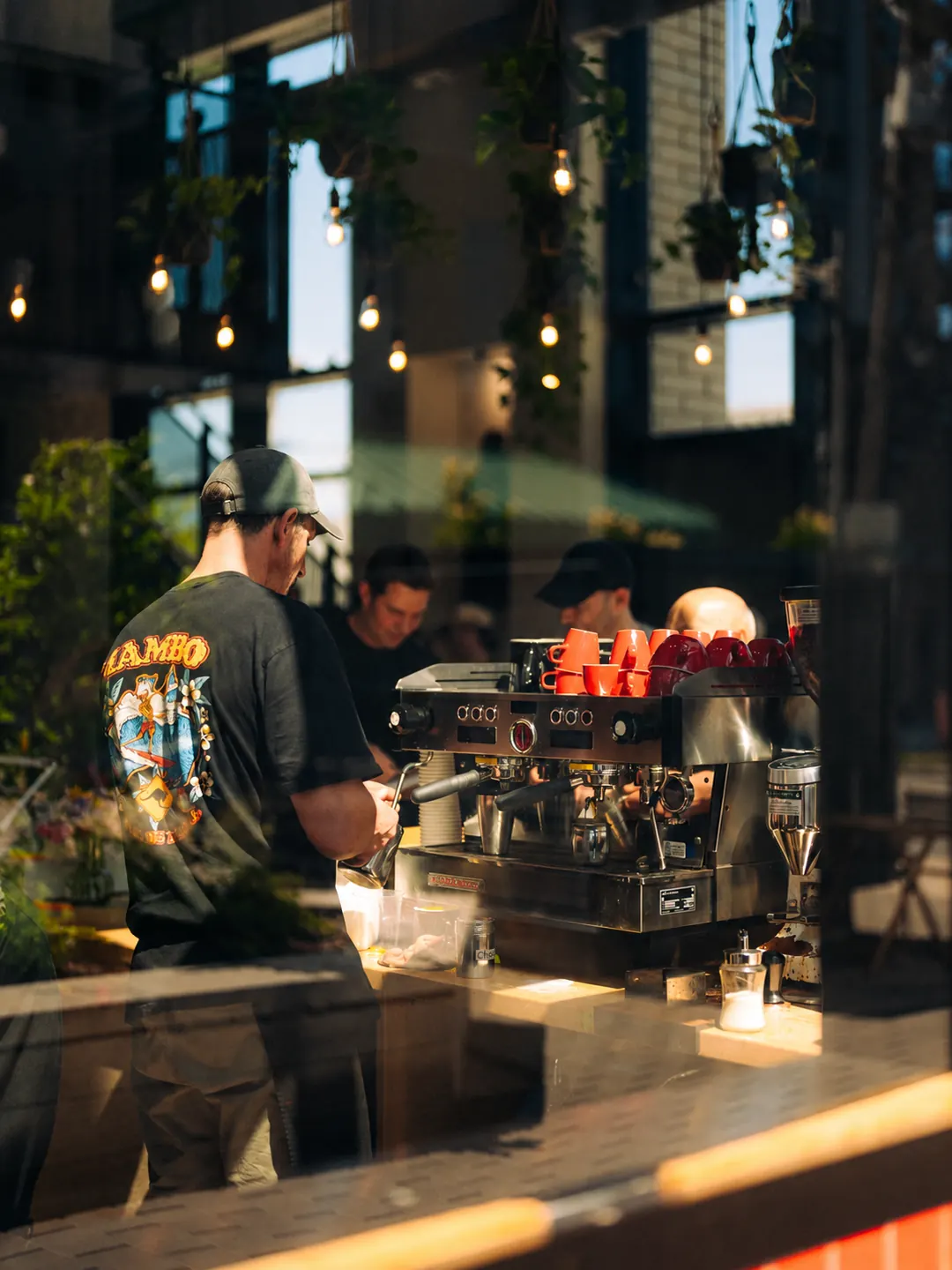 The coffee bar and baristas seen through the café window